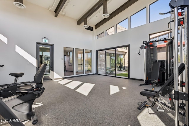 gym featuring baseboards and a high ceiling