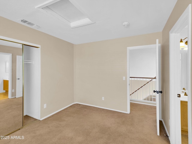 13620 N 82nd Ln, Peoria, AZ 85381 - unfurnished bedroom featuring light colored carpet, baseboards, a closet, and attic access