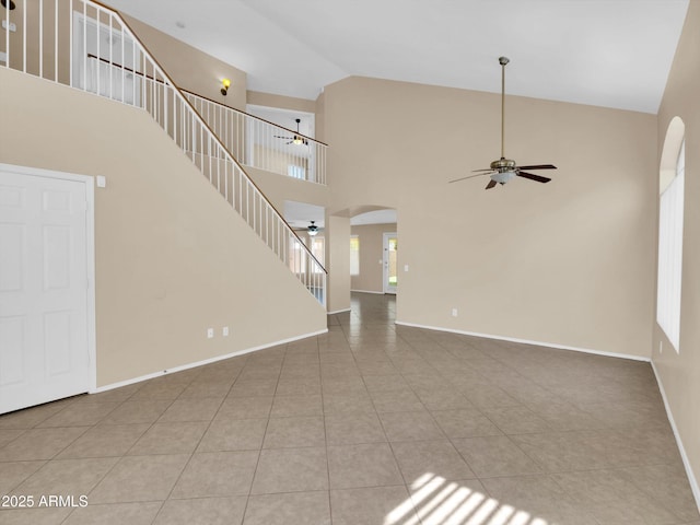 13620 N 82nd Ln, Peoria, AZ 85381 - unfurnished living room with ceiling fan, stairs, high vaulted ceiling, tile patterned floors, and arched walkways