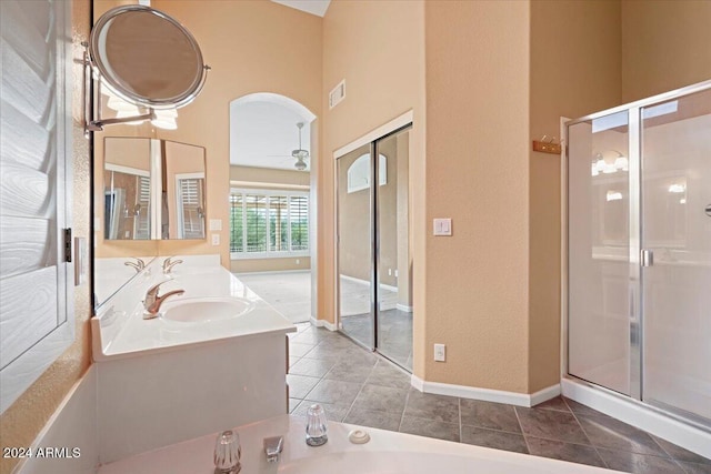 bathroom featuring ceiling fan, tile patterned floors, an enclosed shower, and a towering ceiling