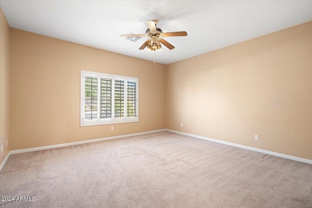 carpeted spare room featuring ceiling fan