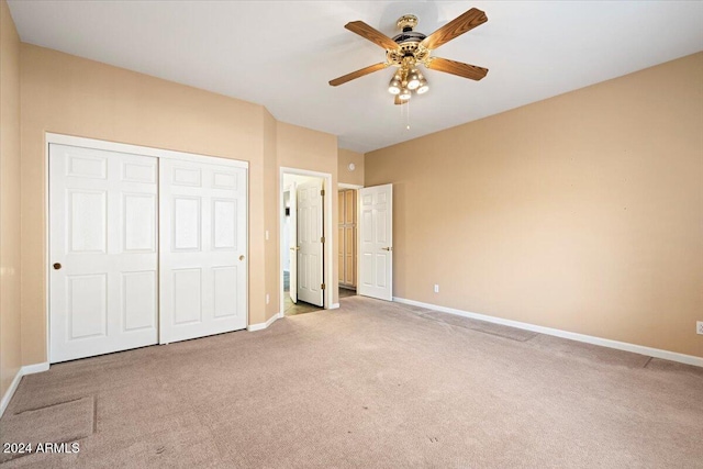 unfurnished bedroom with light colored carpet, ceiling fan, and a closet