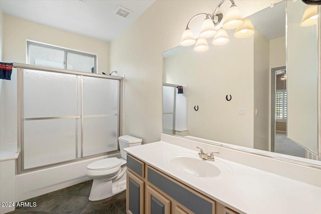 full bathroom with tile patterned floors, toilet, bath / shower combo with glass door, a chandelier, and vanity