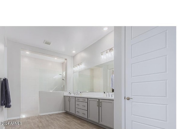 bathroom featuring a shower, hardwood / wood-style floors, and vanity