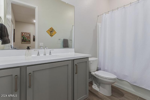 full bathroom with hardwood / wood-style floors, vanity, toilet, and shower / bath combo