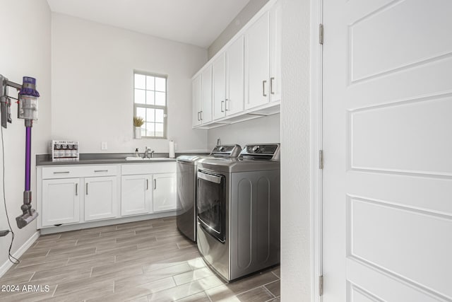 washroom featuring washer and dryer, cabinets, and sink