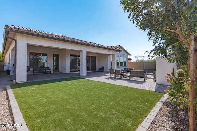 rear view of property with a lawn, a patio area, and an outdoor living space