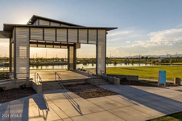 view of property's community with a water view and a lawn