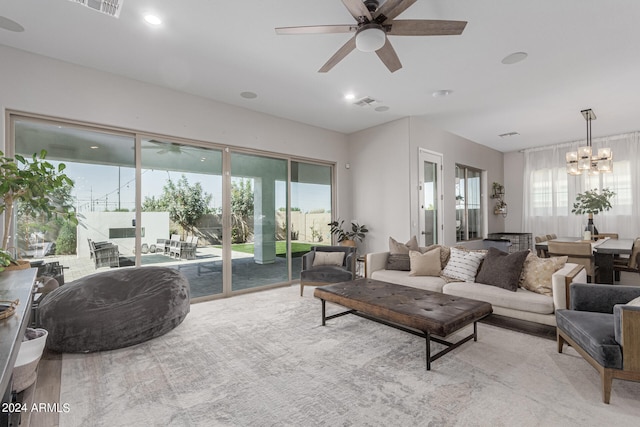 living room featuring ceiling fan with notable chandelier