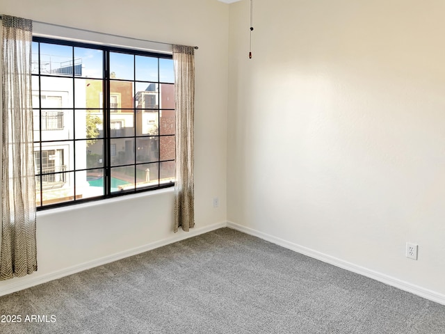 carpeted spare room with baseboards