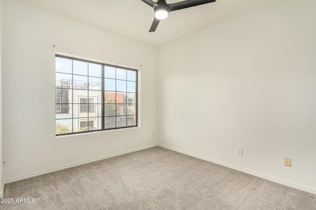 carpeted spare room with baseboards and ceiling fan