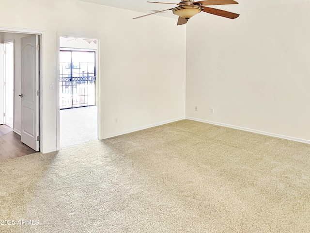 carpeted spare room with a ceiling fan and baseboards