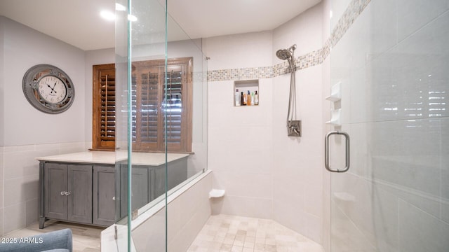 bathroom featuring tile walls and a shower with shower door