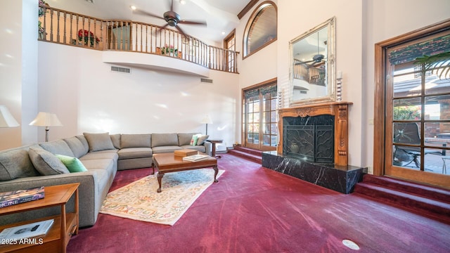 carpeted living room featuring a high ceiling and ceiling fan