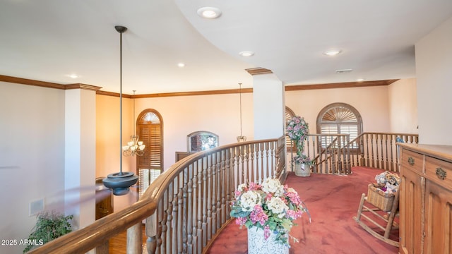 hallway featuring carpet floors, crown molding, and a chandelier