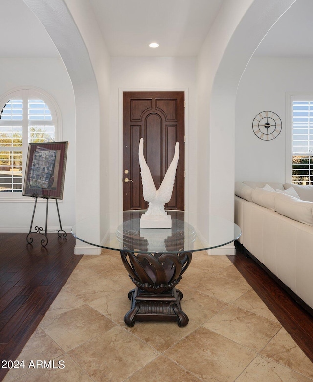 entryway with a healthy amount of sunlight, arched walkways, and baseboards