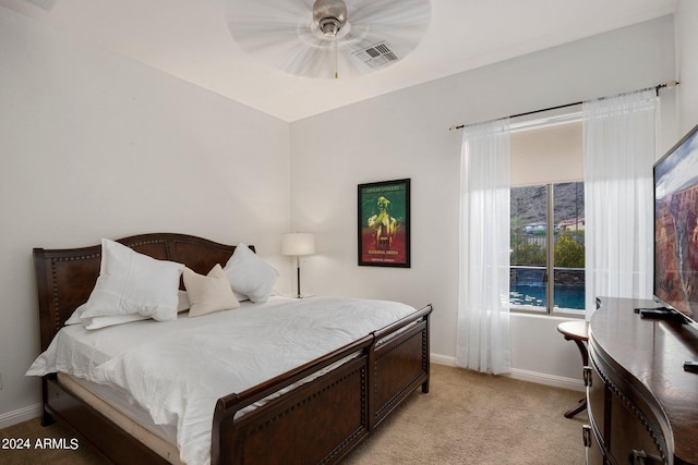 bedroom featuring visible vents, baseboards, light colored carpet, and a ceiling fan