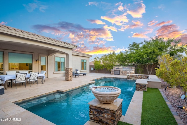pool at dusk featuring a patio area, a fenced in pool, exterior kitchen, and a fenced backyard