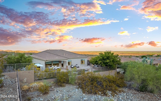 back of house featuring a patio area, stucco siding, a tile roof, and a fenced backyard
