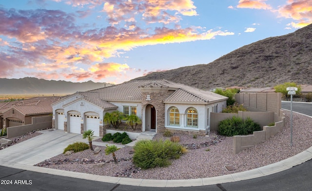 view of front of home featuring an attached garage, fence, stucco siding, driveway, and a mountain view