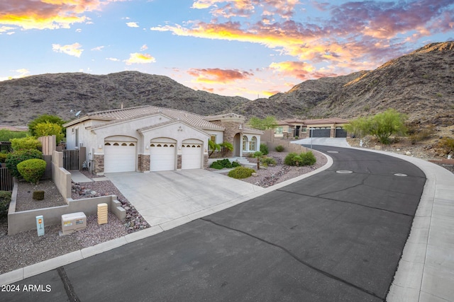 view of front of house with fence, stucco siding, driveway, stone siding, and an attached garage