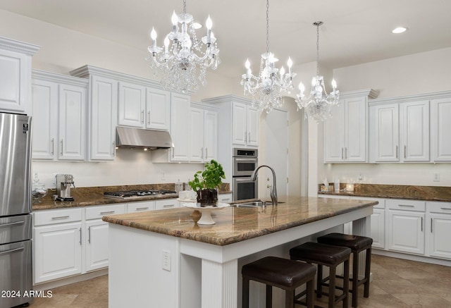 kitchen featuring an inviting chandelier, a sink, appliances with stainless steel finishes, under cabinet range hood, and white cabinetry