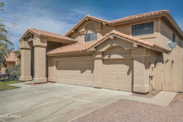 view of front of home featuring fence, a tile roof, stucco siding, and concrete driveway