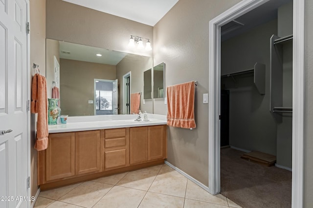 19667 N 260th Ln N, Buckeye, AZ 85396 - bathroom featuring vanity, tile patterned flooring, a walk in closet, and baseboards