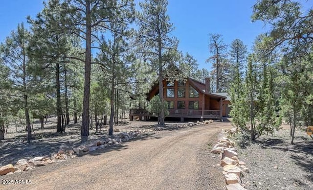 chalet / cabin with a chimney and driveway