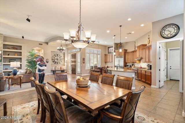 dining space featuring sink, built in features, and a notable chandelier