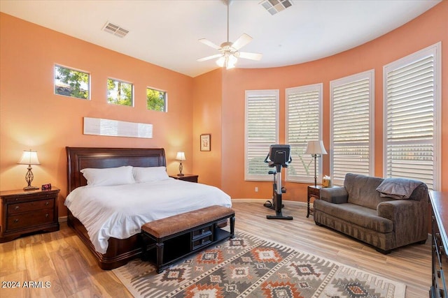 bedroom with multiple windows, hardwood / wood-style floors, and ceiling fan