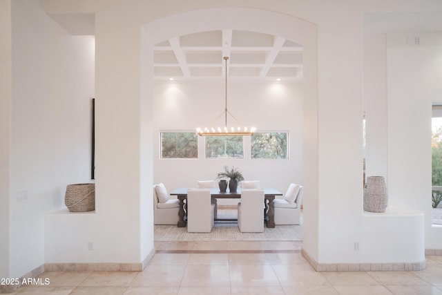 dining room featuring coffered ceiling, light tile patterned floors, plenty of natural light, and an inviting chandelier