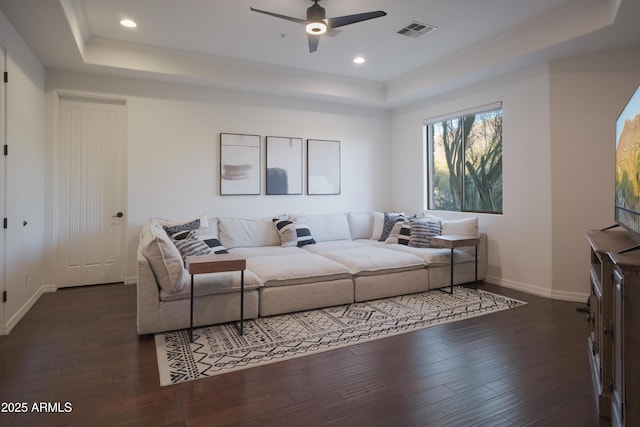 interior space with dark hardwood / wood-style flooring, a tray ceiling, and ceiling fan