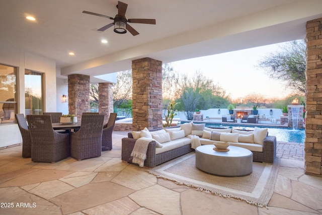 patio terrace at dusk with pool water feature, ceiling fan, an outdoor hangout area, and a fenced in pool