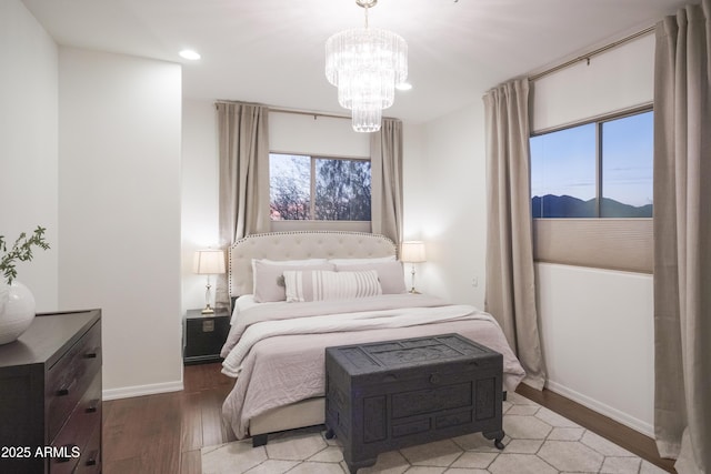 bedroom with a mountain view, light hardwood / wood-style floors, and a chandelier