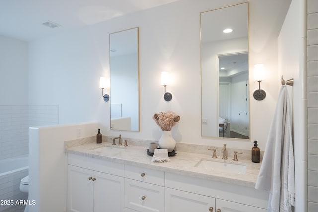 bathroom with vanity and a relaxing tiled tub