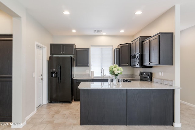 kitchen featuring sink, light stone countertops, kitchen peninsula, and black appliances