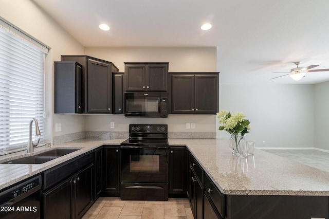 kitchen featuring light stone countertops, black appliances, kitchen peninsula, and sink