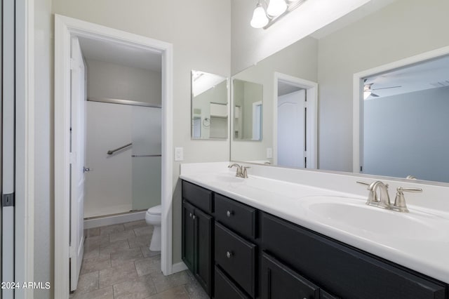 bathroom with ceiling fan, walk in shower, vanity, and toilet