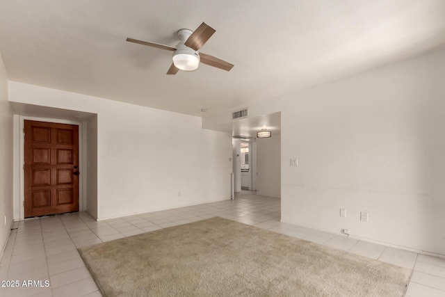 spare room with a ceiling fan, visible vents, and light tile patterned floors
