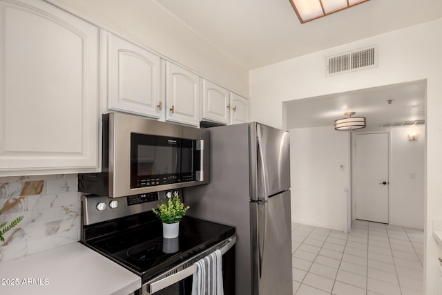 kitchen with white cabinets, stainless steel appliances, light tile patterned floors, tasteful backsplash, and visible vents