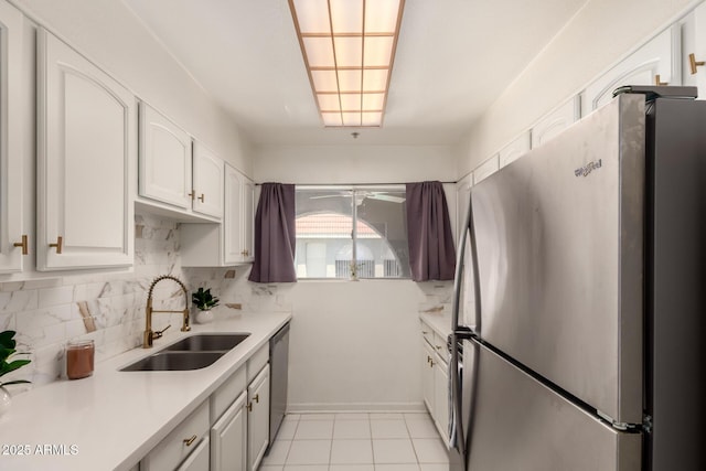 kitchen featuring light countertops, white cabinets, tasteful backsplash, a sink, and appliances with stainless steel finishes