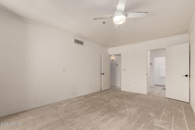 unfurnished bedroom featuring crown molding, ceiling fan, visible vents, and light carpet