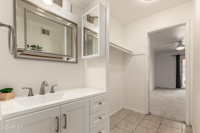 bathroom with visible vents, vanity, baseboards, tile patterned floors, and a ceiling fan
