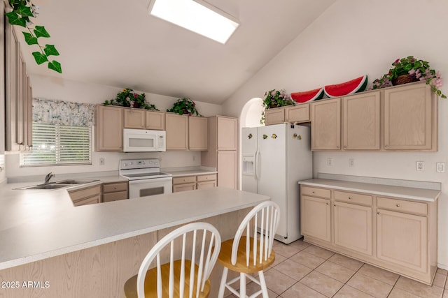 kitchen featuring white appliances, a sink, lofted ceiling, a peninsula, and light countertops