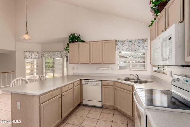 kitchen with white appliances, a sink, a peninsula, light brown cabinets, and light tile patterned floors