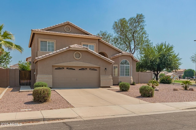 mediterranean / spanish house with stucco siding, concrete driveway, a garage, and a gate
