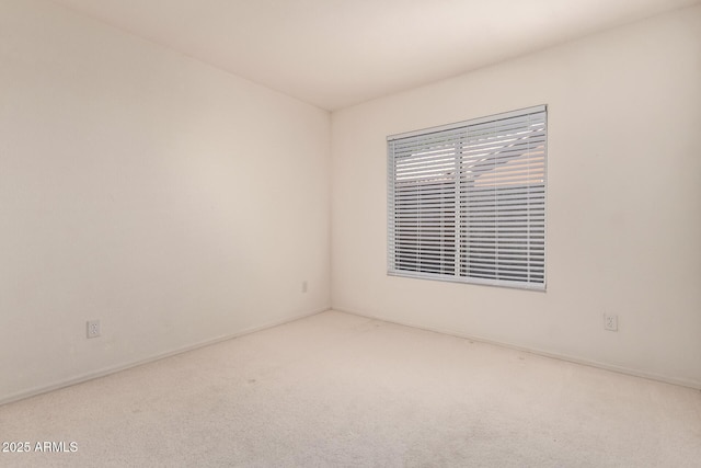 unfurnished room with carpet and baseboards