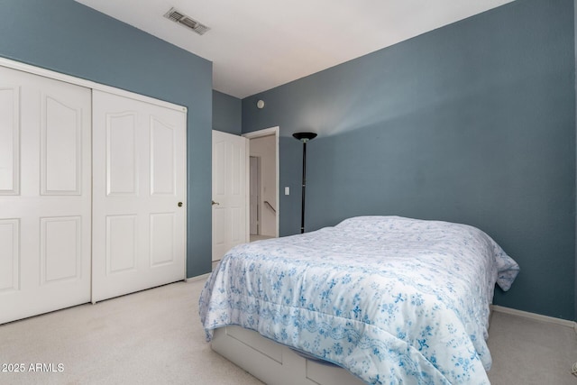 bedroom with light colored carpet, a closet, and baseboards
