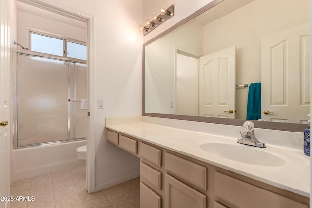 bathroom featuring toilet, vanity, bath / shower combo with glass door, and baseboards
